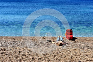 Mom with a newborn lying on the beach