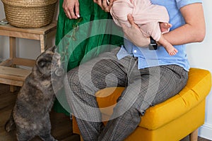 Mom and newbornbaby at home. Pet at home. Green dress colour