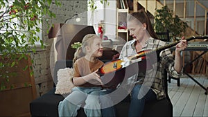 Mom persuades her daughter to play the guitar, but she refuses