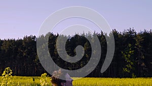 Mom played with the baby in the rapeseed field and throws it.