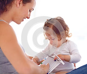 Mom playing with baby girl in home with toys, bonding and child care with support in morning on bed. Happy woman