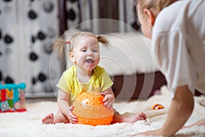 Mom playing ball with baby indoor