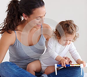Mom playing with happy baby in home with toys, bonding and child care with support in morning on bed. Woman, playful