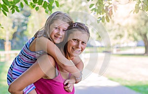 Mom playing with her child outdoors in the park in a sunny day