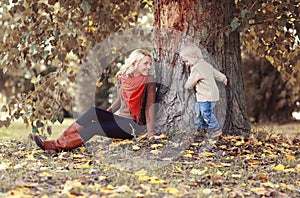 Mom playing with son child in autumn park