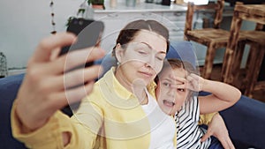 Mom plays with her daughter at home a take a selfie. Happy family kid dream stay home concept. Mom plays with daughter