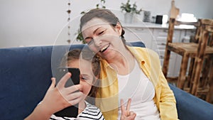 mom plays with her daughter at home a take a selfie. happy family kid dream stay home concept. mom plays with fun