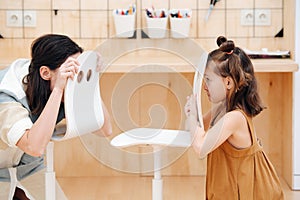 Mom plays with her daughter, they look at each other for fun