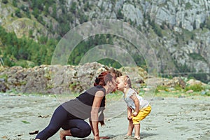 Mom plays with her daughter in the sand