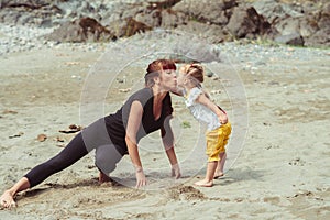 Mom plays with her daughter in the sand