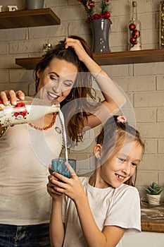 Mom pours a little daughter milk in a glass