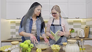 Mom and preteen daughter cooking together at home in kitchen apple pie