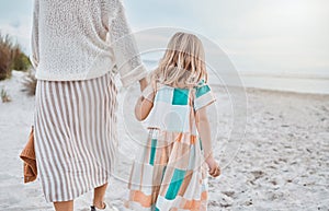 Mom promised me a beach day, come rain or sunshine. a little girl spending the day at the beach with her mother.