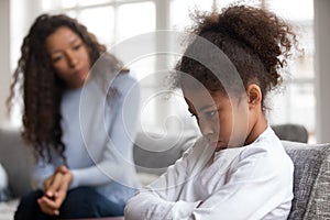 Mom or psychologist tries to talk to upset african girl photo