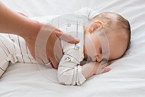 Mom putting baby to sleep in baby bed