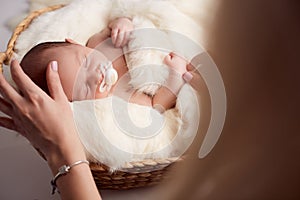 Mom putting baby to sleep in baby bed at home