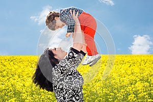 Mom raise uop her son in canola field