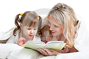 Mom reading a book to kid lying in the bed