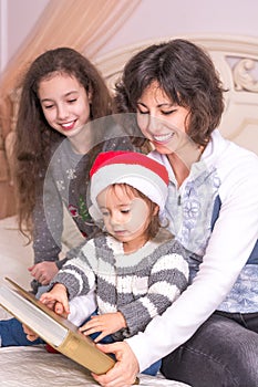 Mom reading a Christmas story with children.