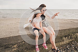 Mom rests with her daughter on the sea. Parents tell the child interesting stories. A mother loves her child dearly