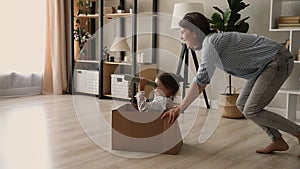 Mom riding daughter while she sitting in cardboard box