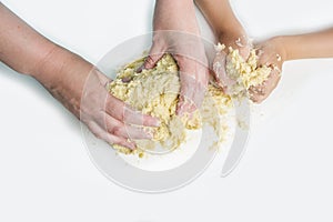 Mom`s and kid`s hand kneading the dough. Cooking dough for baking in home kitchen. Preschooler skills, little helper. Family
