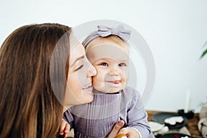 Mom smiles and kisses her daughter. A happy family. Portrait of a mother.