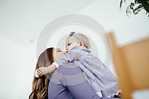 Mom smiles and kisses her daughter. A happy family. Portrait of a mother.