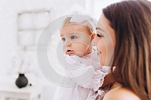 Mom smiles and kisses her daughter. A happy family. Portrait of a mother.