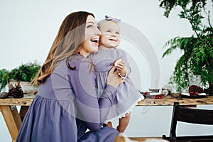 Mom smiles and kisses her daughter. A happy family. Portrait of a mother.