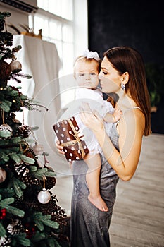 Mom smiles and kisses her daughter. A happy family. Portrait of a mother.