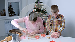 Mom and son are baking making cooking gingerbread cookies together at home.