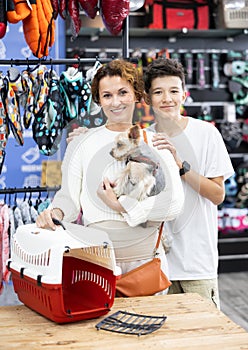 Mom and son choose pet carrier for small animal nursling dog of dwarf breed Yorkshire Terrier