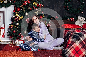 Mom with son at christmas tree with gifts new year garland winter