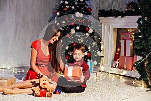 Mom with son decorate Christmas tree new year gifts Garland lights