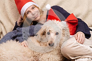 Mom, son and dog in New Year's hats are smiling during the Christmas holidays. Happy family having fun