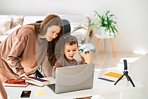 Mom and son doing school homework on laptop.