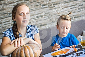 Mom with son draw a pumpkin for Halloween photo