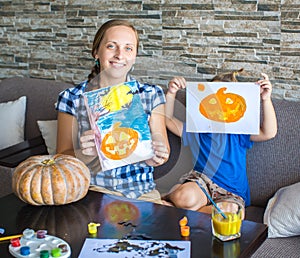 Mom with son draw a pumpkin for Halloween photo