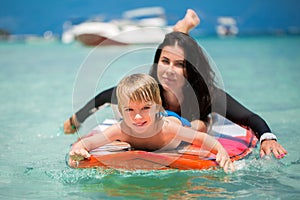 Mom and son have surfing in the ocean on the blackboard.