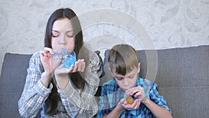 Mom and son inflate a big bubbles from a slimes. Play with slime.