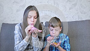 Mom and son inflate a big bubbles from a slimes. Play with slime.