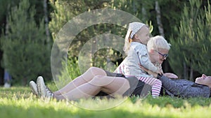 Mom, son and little daughter are playing with a stone scissors paper in the par