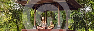 Mom and son meditate practicing yoga in the traditional balinesse gazebo BANNER, long format