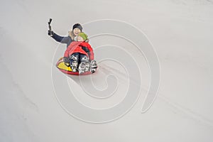 Mom son ride on an inflatable winter sled tubing. Winter fun for the whole family