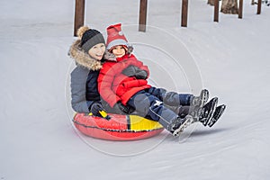 Mom son ride on an inflatable winter sled tubing. Winter fun for the whole family