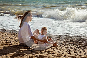 Mom and son sit by the sea on a sunny summer day