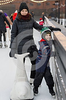 Mom and son skate on the ice rink