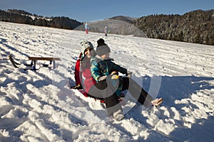 Mom and son sledding on snow