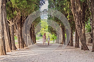 Mom and son tourists walking together in Montenegro. Panoramic summer landscape of the beautiful green Royal park